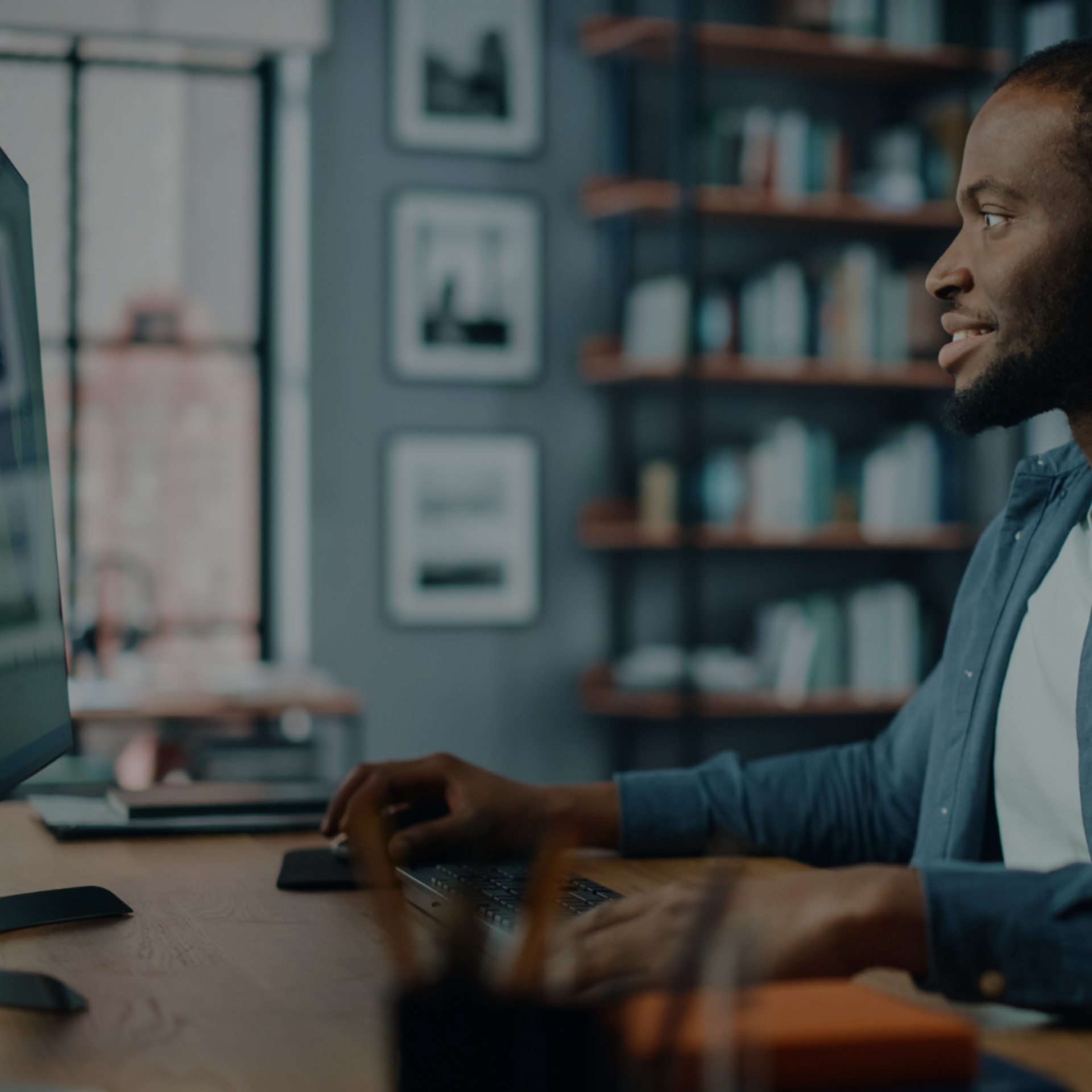 Handsome Black African American Specialist Working on Desktop Computer in Creative Home Living Room. Freelance Male is Working on a Finance Presentation Report for Clients and Employer