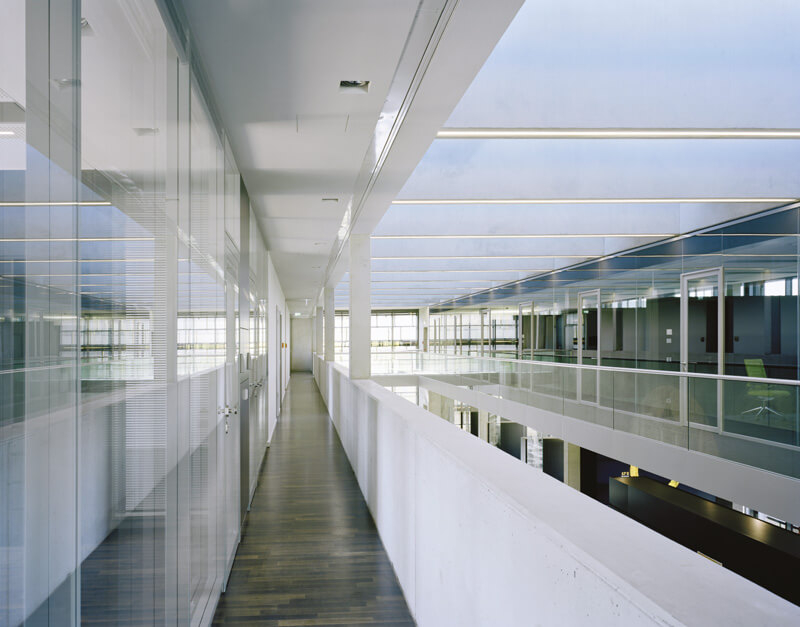 Stockwerk eines modernen Bürogebäudes mit viel Glas und einem Atrium