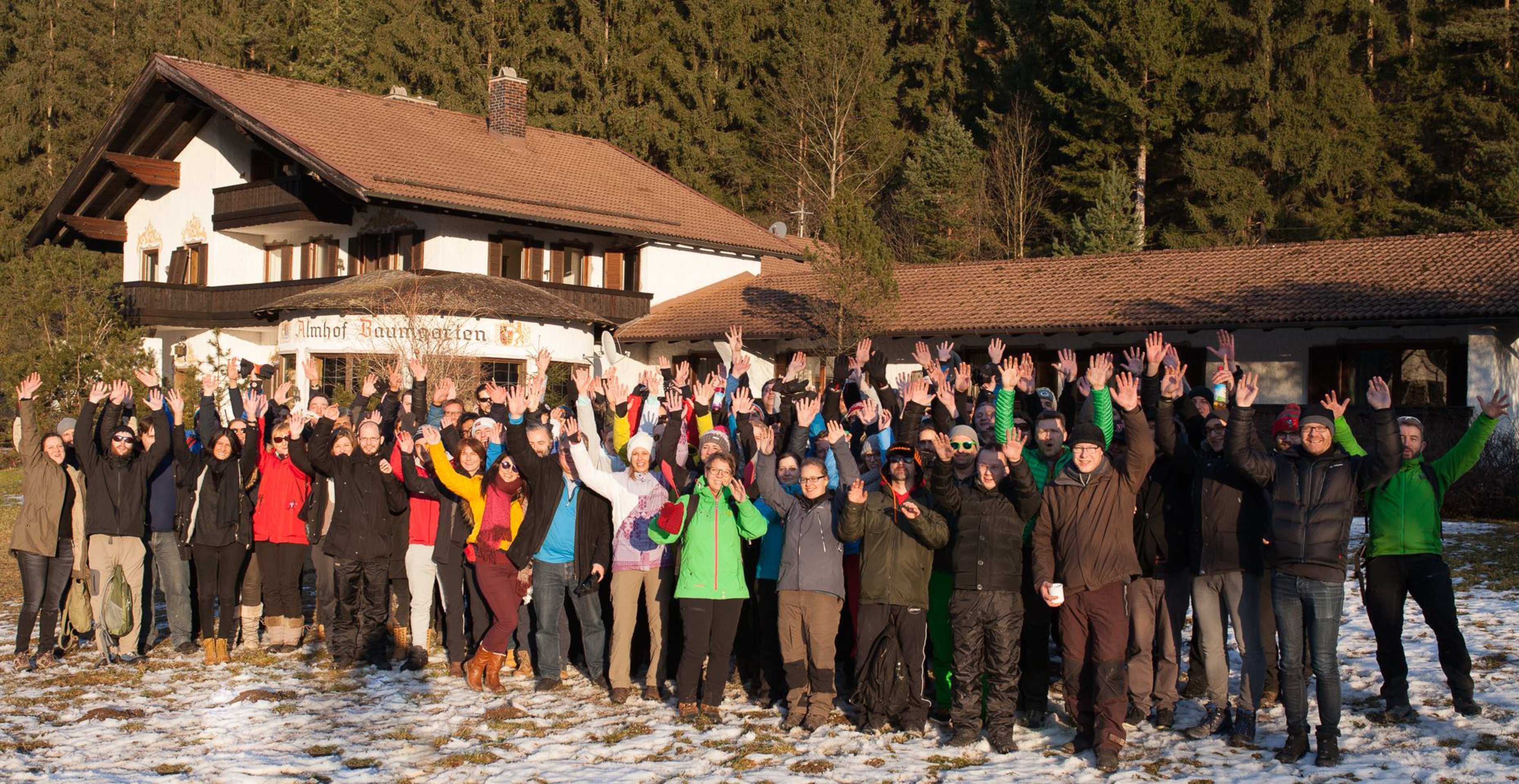Gruppenfoto der jubelnden Mitarbeitenden der novaCapta im Schnee vor einer Berghütte